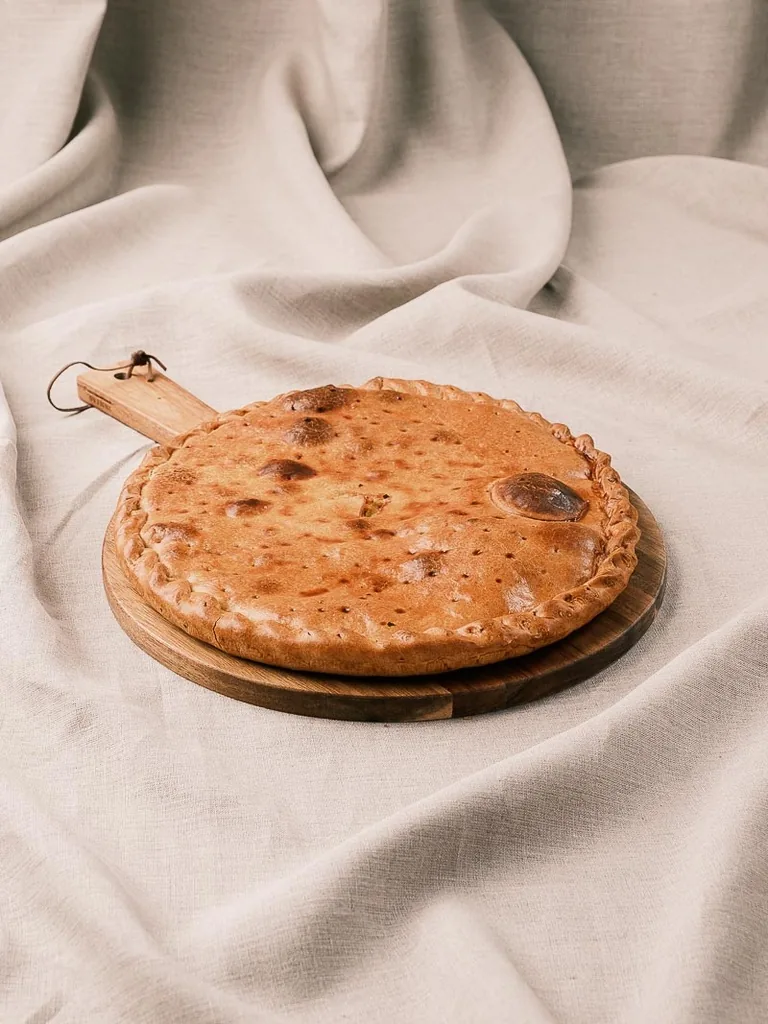 Empanada gallega de zamburiñas sobre tabla de madera